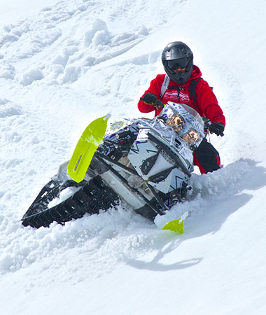 Snowmobile Rider going down slope